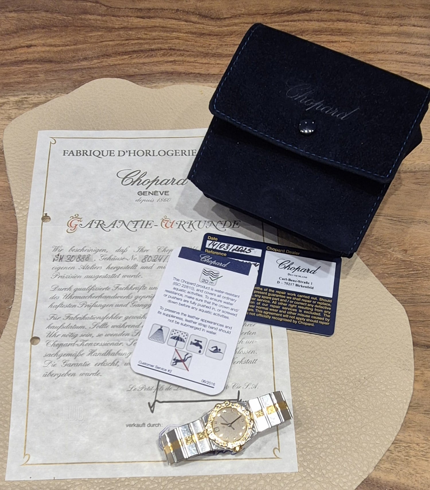 chopard-damenuhr-liegend-auf-zertifikat-quarz-Gold-juwelier-risch