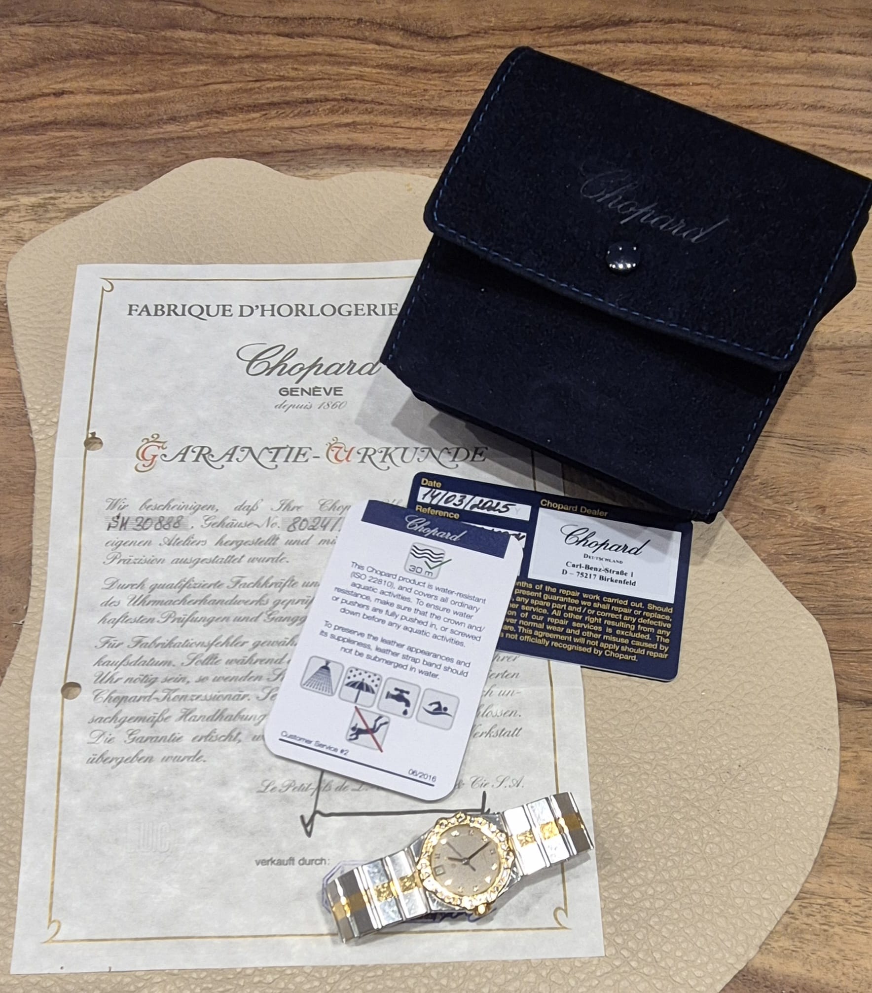 chopard-damenuhr-liegend-auf-zertifikat-quarz-Gold-juwelier-risch
