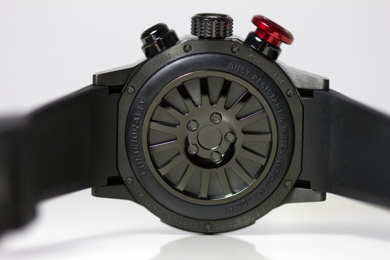 Uhr liegende von unten
schwarze EDOX Uhr mit schwarzem Kautschukband, Drücker für Stoppfunktion und Uhrstellung auf linker Seite der Uhr. 
Uhrreferenz: 10302-37N-NIN